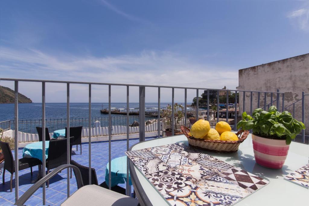 un tavolo con un cesto di frutta sul balcone di Luxury apartments Caucich a Città di Lipari