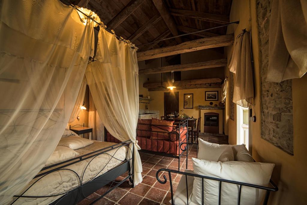 Cerretto LangheにあるDimora Storico Romantica Il Sole E La Lunaのベッドルーム1室(カーテン付きのベッド1台付)