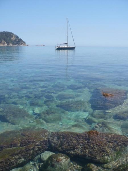 a sail boat in the water near the shore at Villa Montemar in Tossa de Mar