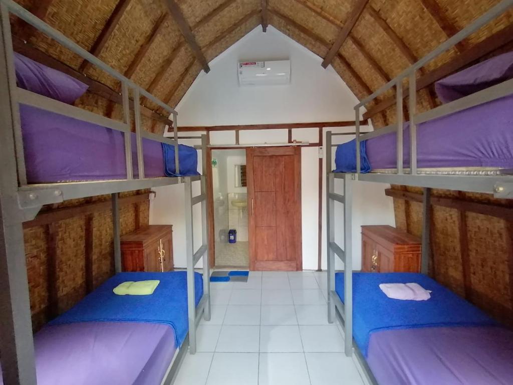 a dorm room with three bunk beds in it at Bale Hostel in Kuta Lombok