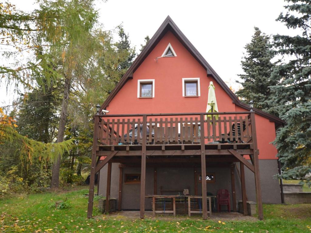 a large red house with a large deck at Holiday home in Erzgebirge Mountains with terrace in Mezihoří