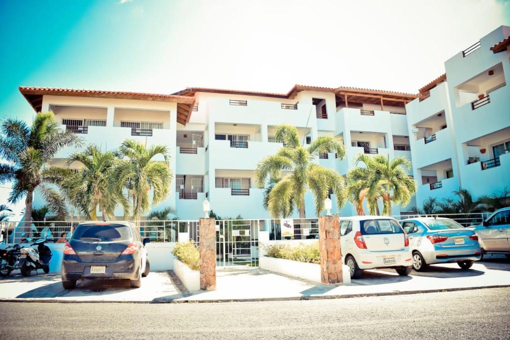 ein Parkplatz vor einem Gebäude mit Palmen in der Unterkunft Vittoria House Apartments 209-210 in Bayahibe