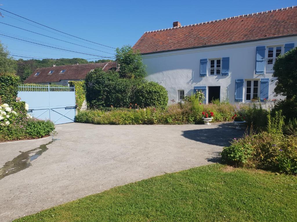 a white house with a gate and a driveway at Le champ de l&#39;eau in Crécy-la-Chapelle