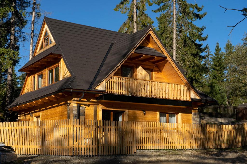 a log cabin with a fence in front of it at Pająkówka Apartament I in Kościelisko
