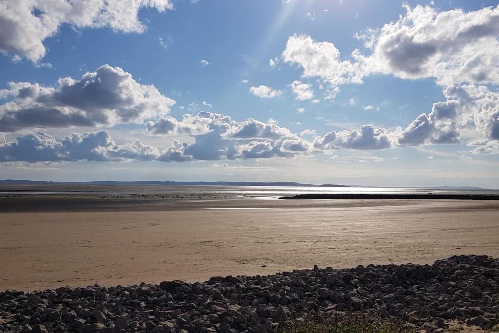 une plage avec des rochers et des nuages dans le ciel dans l'établissement The Copthorne, à Colwyn Bay