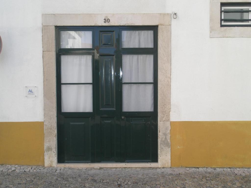 una porta verde con finestre su un edificio di Casa do Arco, Santarém a Santarém