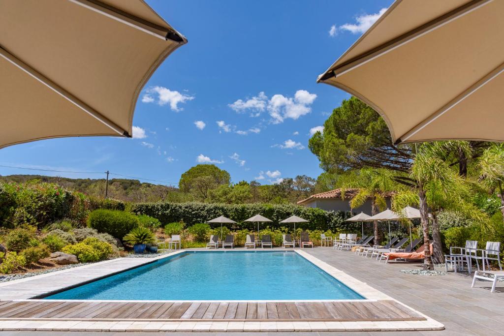 uma piscina num resort com guarda-sóis em Les Pins de Santa Giulia em Porto-Vecchio