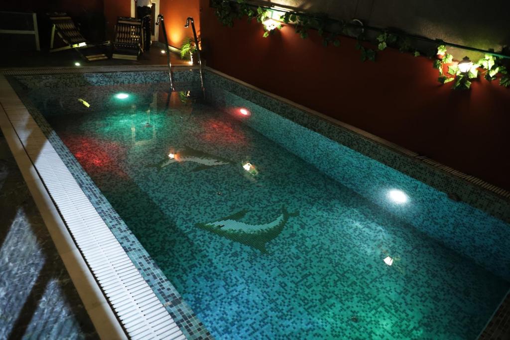 a swimming pool at night with lights in it at Ganesha Palace in Amritsar