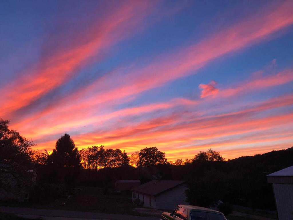 a sunset with a car parked in a parking lot at Smokey Mountain Overlook in Bryson City