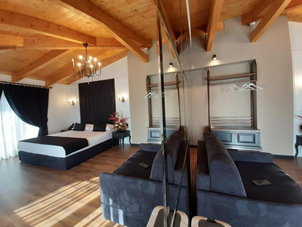 a large bedroom with a bed and a couch at Hotel Kloest in Durrës