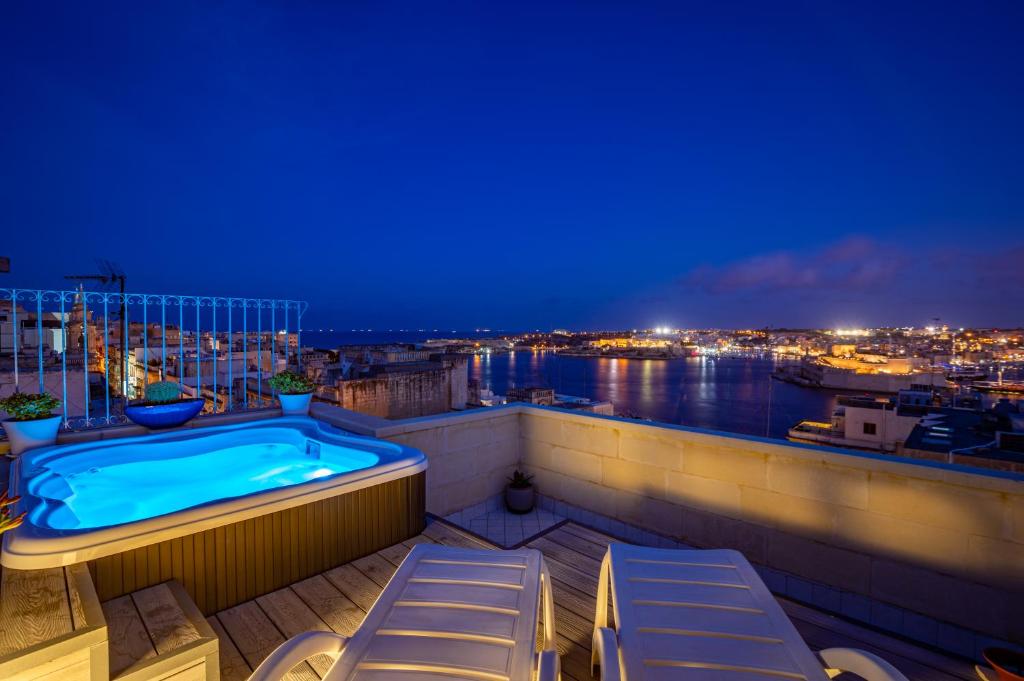 een hot tub op het balkon van een gebouw 's nachts bij Tano's Boutique Guesthouse in Valletta