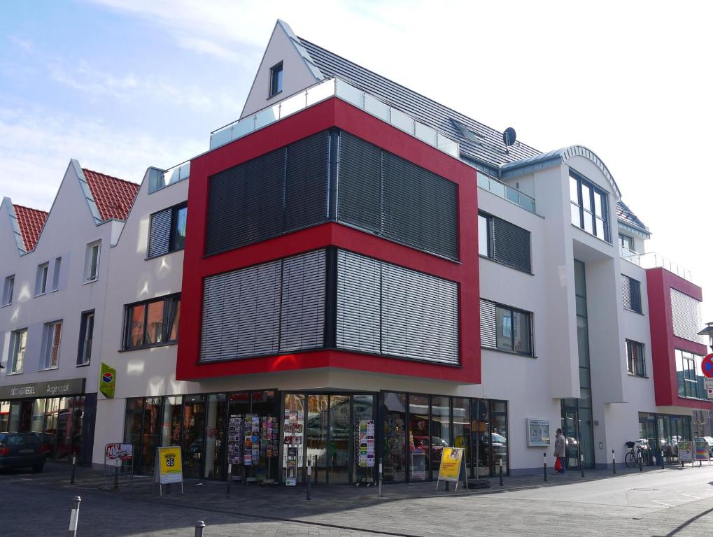 ein rot-weißes Gebäude in einer Stadtstraße in der Unterkunft Vermietung Flaßkamp in Harsewinkel