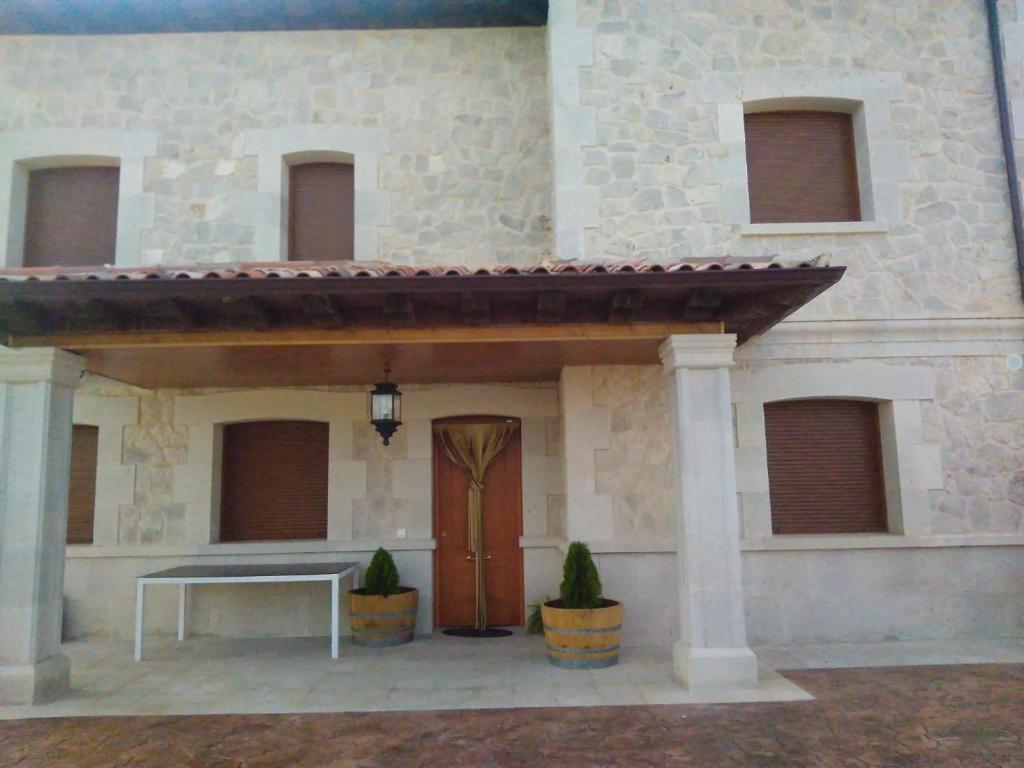 um edifício com uma mesa e uma porta de madeira em Casa Rural La Infanta em Caleruega