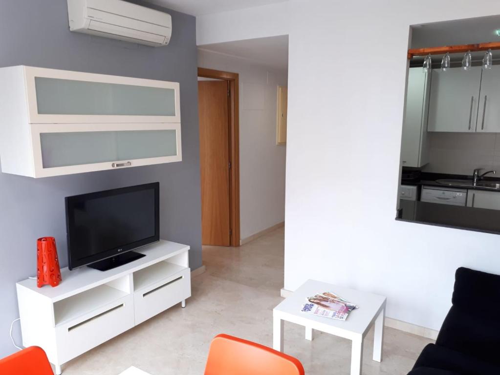 ein Wohnzimmer mit einem TV und einem weißen Entertainment-Center in der Unterkunft Dénia Centro Puerto in Denia