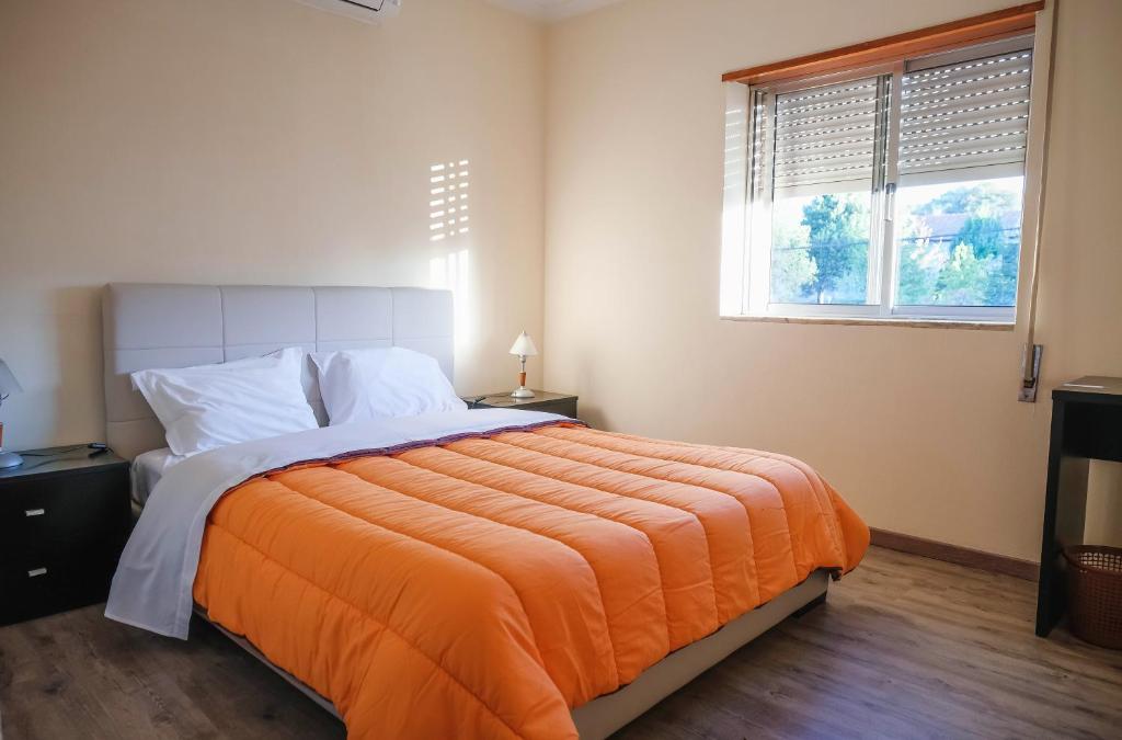 ブラガンサにあるAlojamento Local do Aradoのベッドルーム1室(大型ベッド1台、オレンジの毛布付)