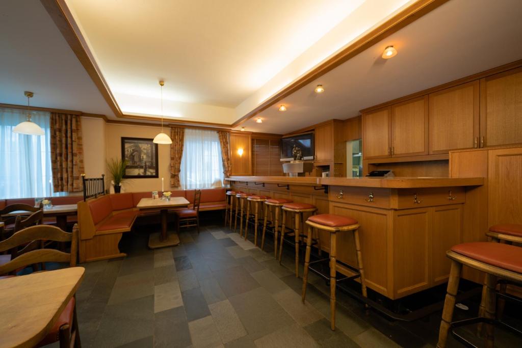 瓦倫多夫的住宿－Hotel Emshof，餐厅设有酒吧,配有桌椅