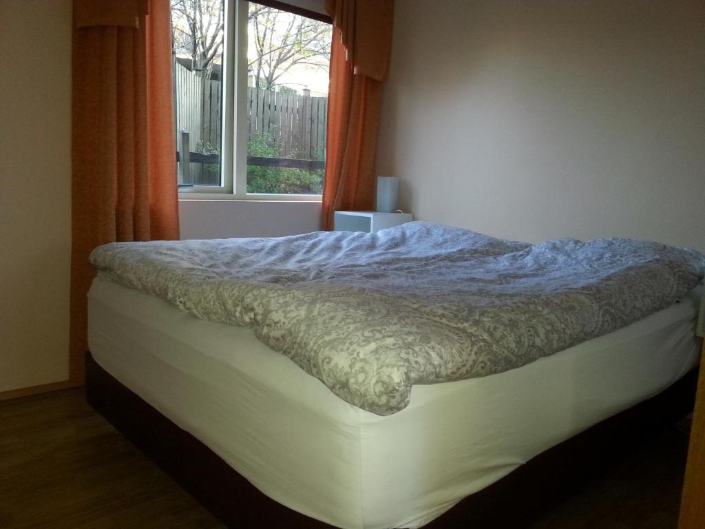 een bed in een slaapkamer met een raam bij Thorshamar - Car Included in Reykjavík