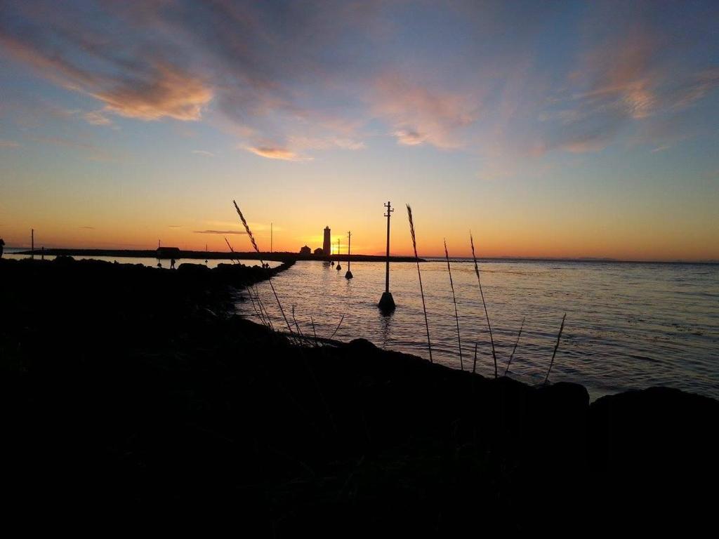 a group of boats in the water at sunset at Quiet, two bedroom apartment in Reykjavík