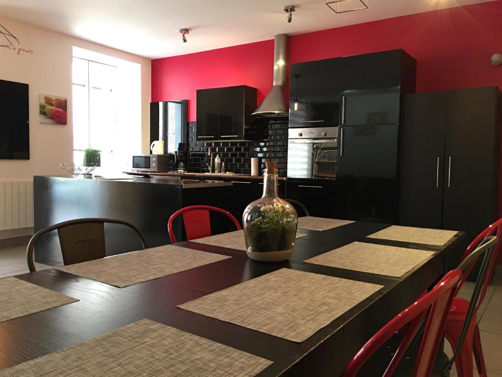 une cuisine aux murs rouges et une table avec une bouteille. dans l'établissement La Halte Effervescente, à Épernay