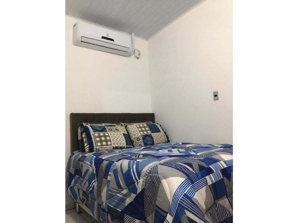 a bedroom with a bed and a air conditioner at Próximo à ACISP, APM, PUC e UFRGS in Porto Alegre