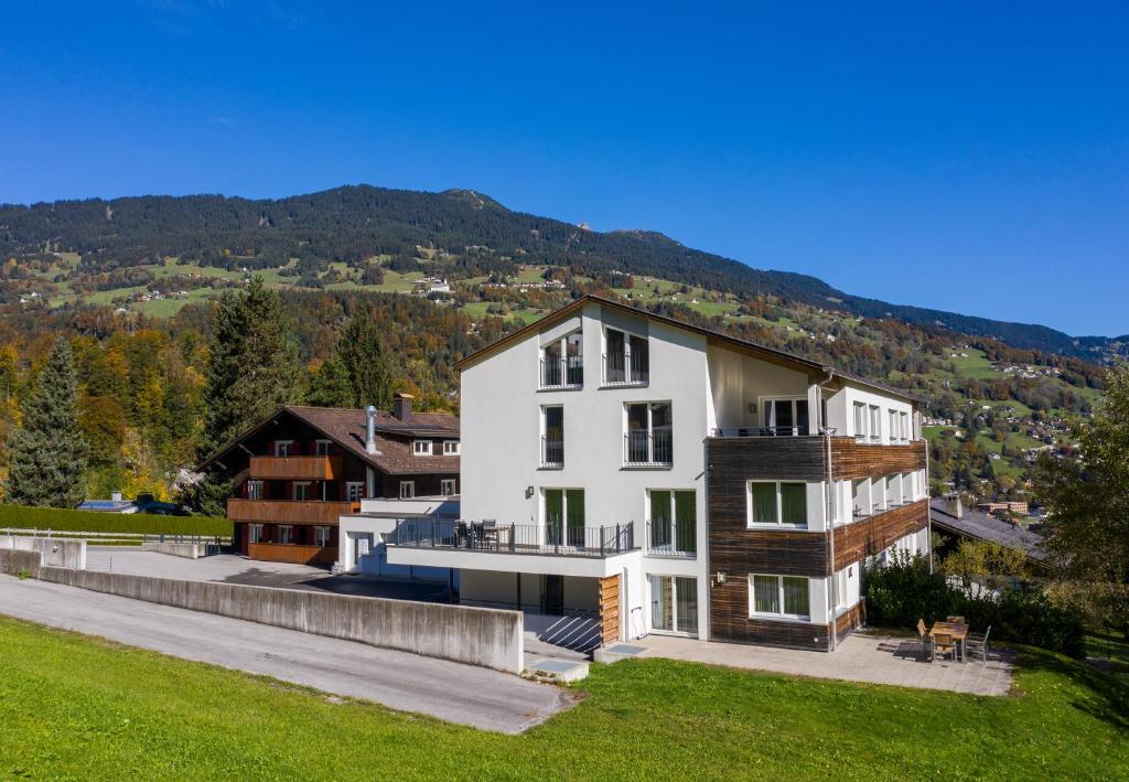 a large white building on top of a green field at Apartments Drei Türme in Schruns-Tschagguns