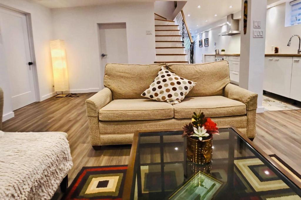 a living room with a couch and a glass table at Cosy apartment at Bossuet road in Montréal