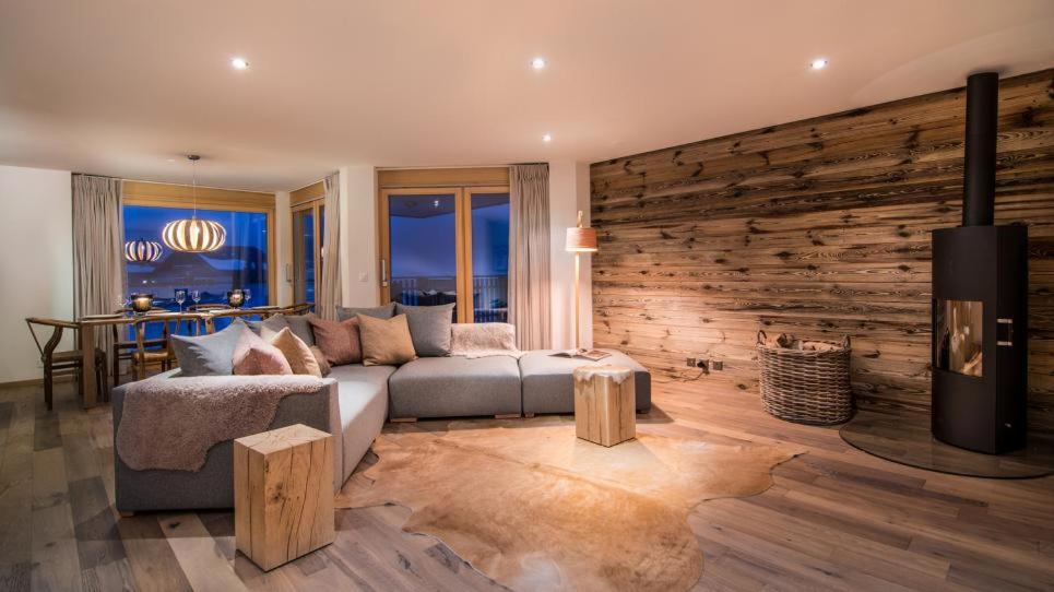uma sala de estar com um sofá e uma parede de madeira em Ski Heaven 7 em Veysonnaz