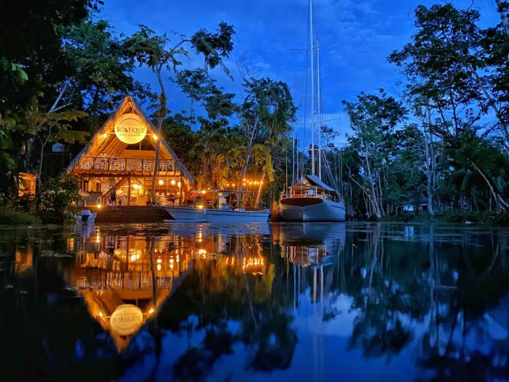 a building with boats in the water at night at Boatique Hotel and Marina in Rio Dulce