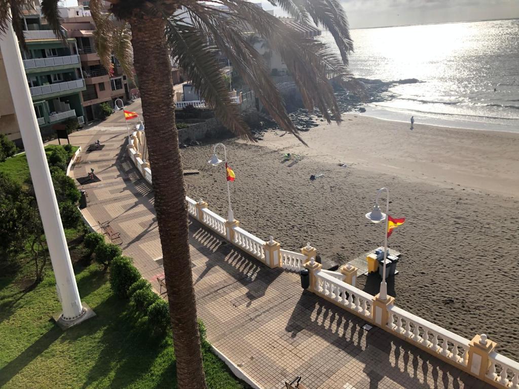an aerial view of a beach with flags and a fence at Espectacular en primera línea de la playa in Telde