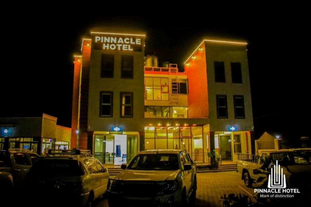 a parking lot in front of a hotel at night at Pinnacle Hotel Mbarara in Mbarara