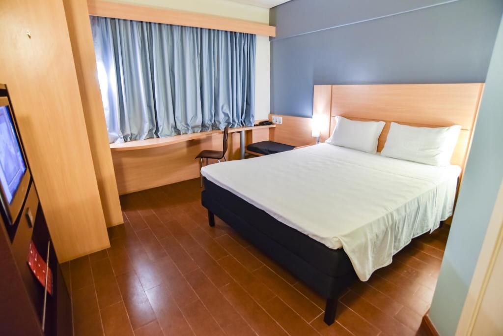 a hotel room with a bed and a television at ibis Sao Luis in São Luís