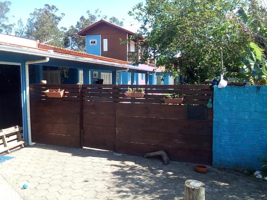 a wooden fence in front of a house at Moradas Vô Ary in Garopaba