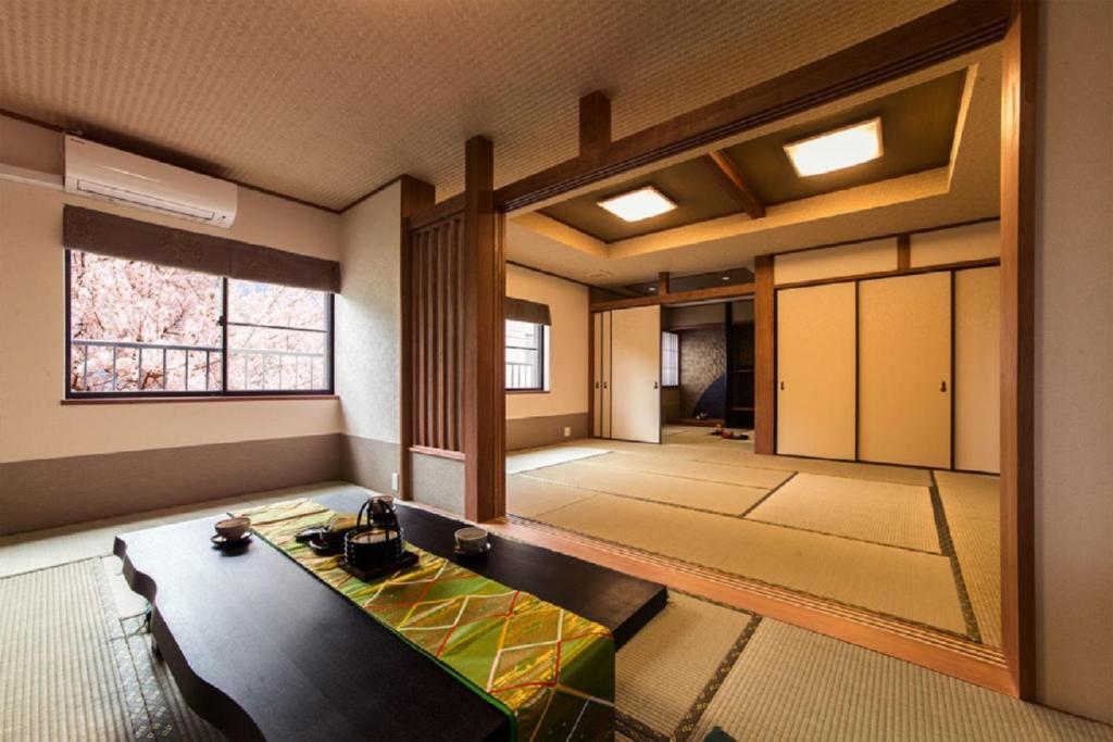 ein Esszimmer mit einem Tisch und einem Fenster in der Unterkunft Show和の宿つちや～豊臣の隠れ茶の間～ in Nagoya