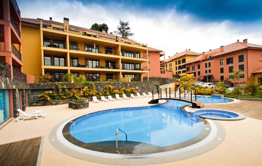 a large swimming pool in front of a building at Madeira Luxury Villas Living Funchal in Funchal