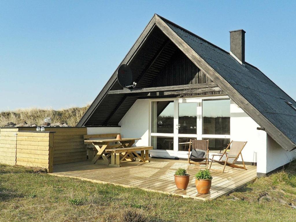 a house with a wooden deck with a picnic table at 6 person holiday home in Ringk bing in Klegod