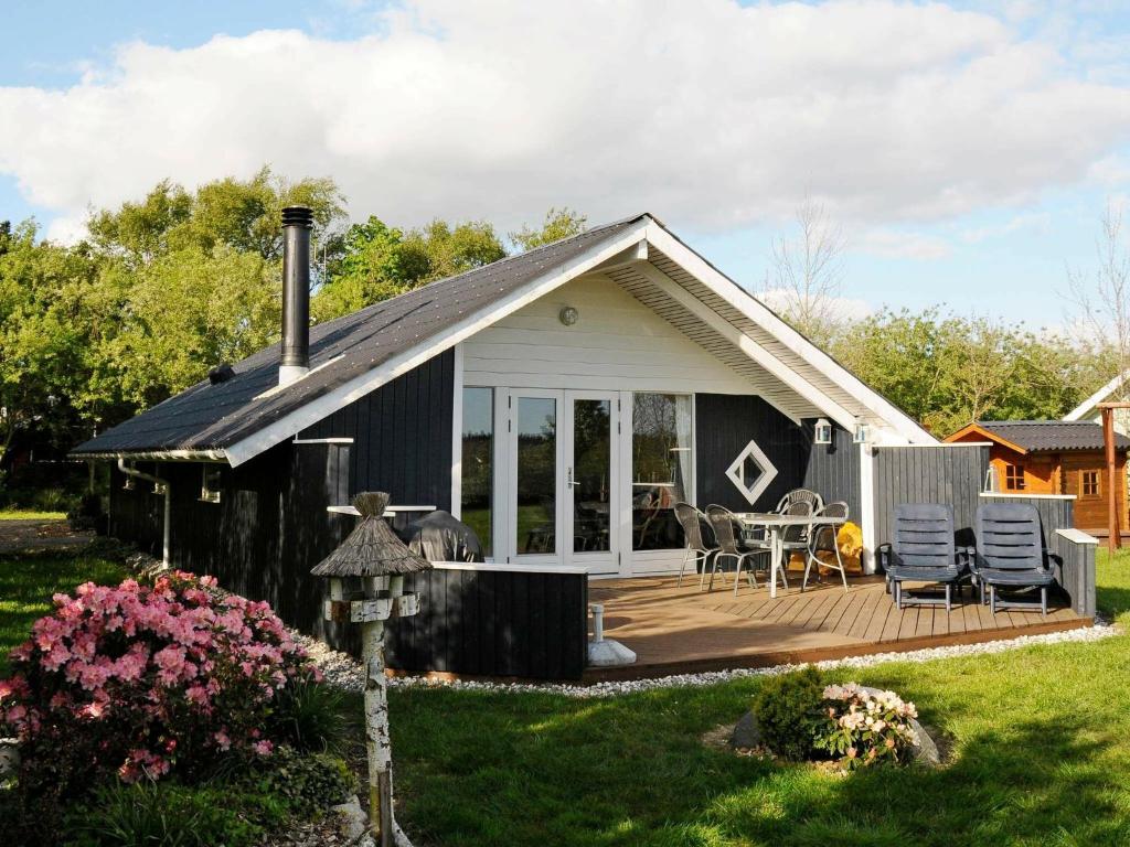 a small house with a deck and a patio at 8 person holiday home in Tarm in Hemmet
