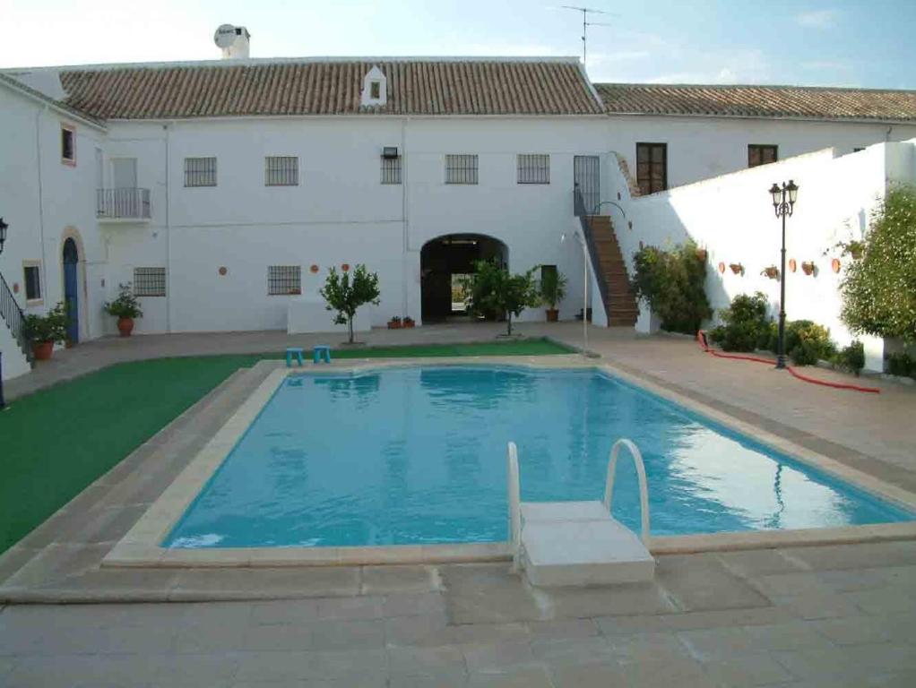 Aguilar de la Frontera的住宿－Hacienda Capricho Andaluz，白色建筑前的大型游泳池
