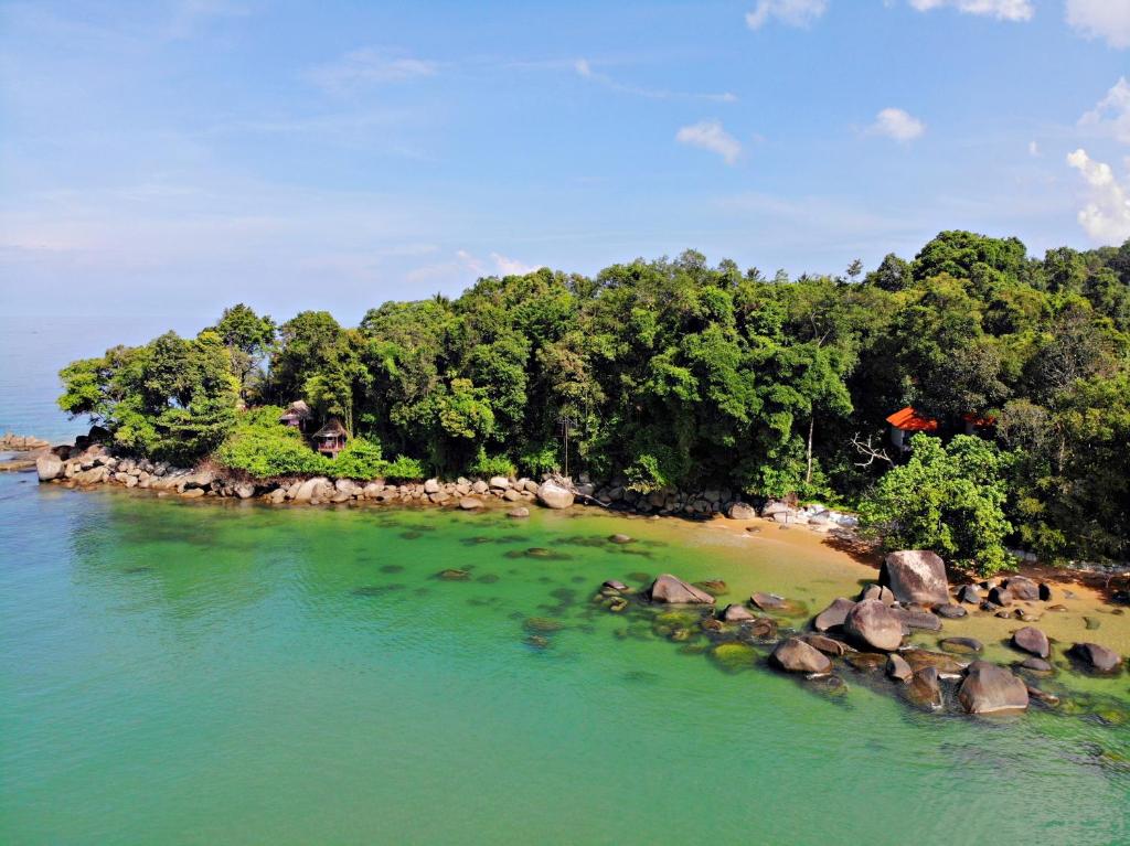 una isla en el agua con árboles y rocas en Poseidon Bungalows en Khao Lak