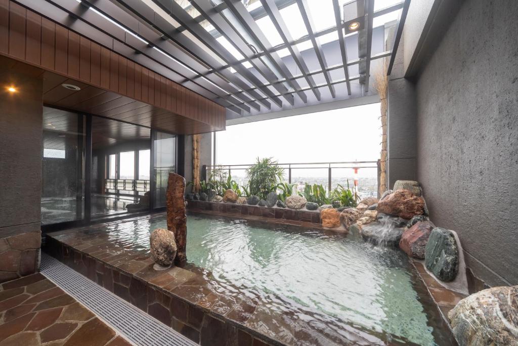 a swimming pool in a building with a large window at Dormy Inn Kawasaki Natural Hot Spring in Kawasaki