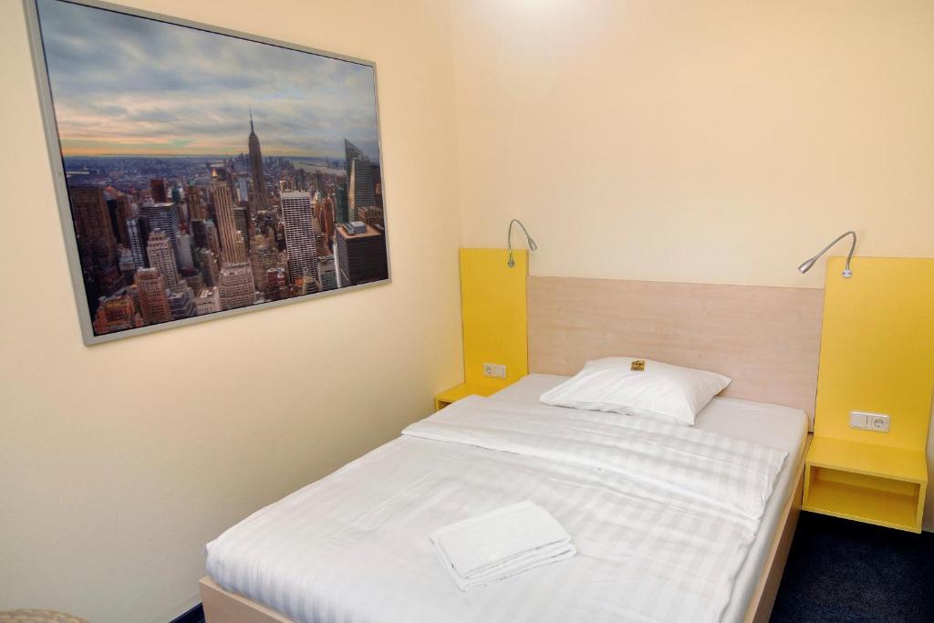 a room with a bed with a picture on the wall at Best Deal Airporthotel Weeze in Weeze