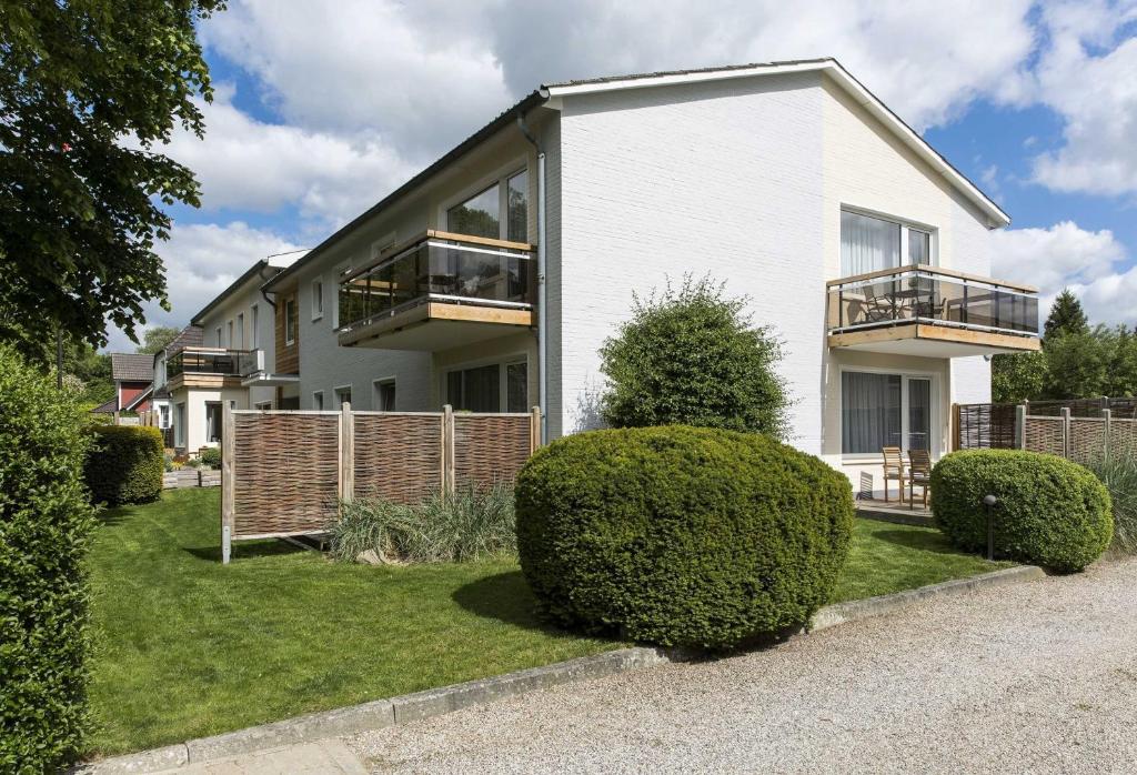 a white house with bushes in front of it at Gaestehaus Schaefersruh in Haffkrug