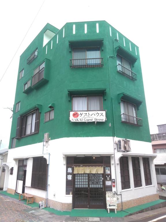 a green and white building with a sign on it at Sakai Guest House AMAMI（堺ゲストハウス奄美） in Setouchi