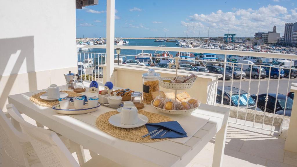 una mesa de desayuno en un balcón con vistas a un barco en B&B Le Terrazze, en Mola di Bari