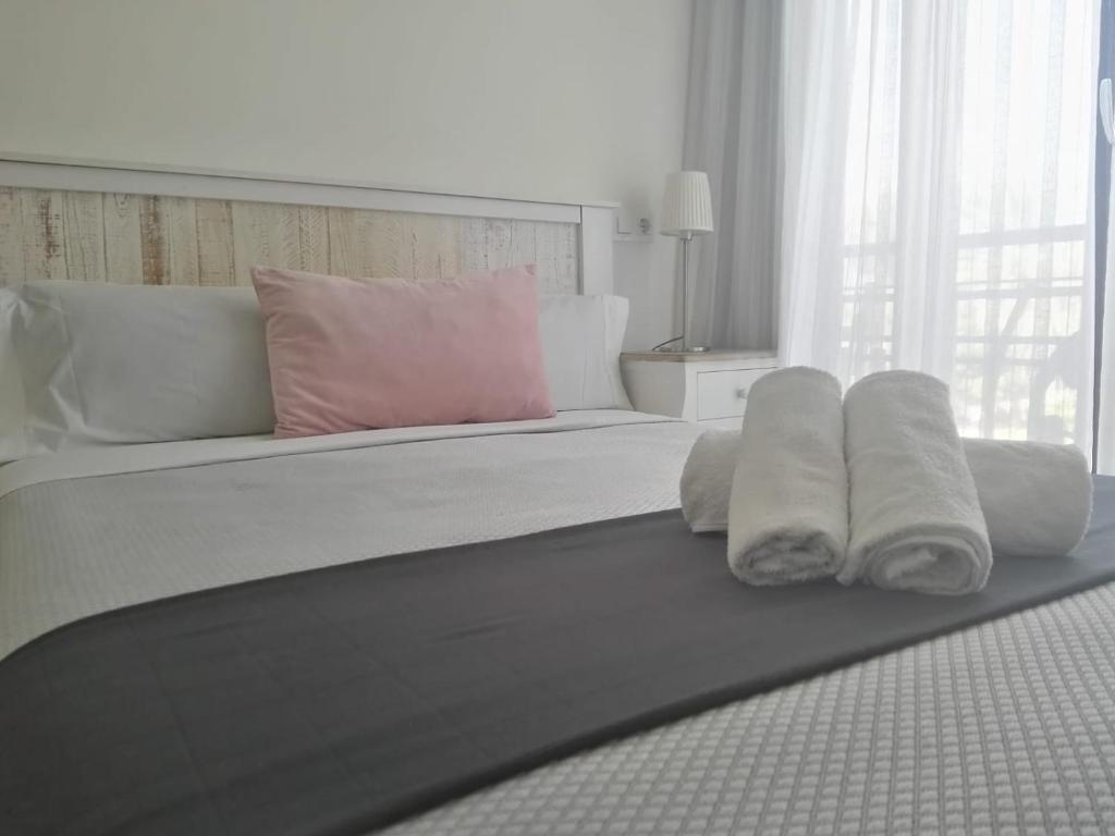 1 dormitorio con 1 cama con toallas en Balcón Al Mar, en Valencia