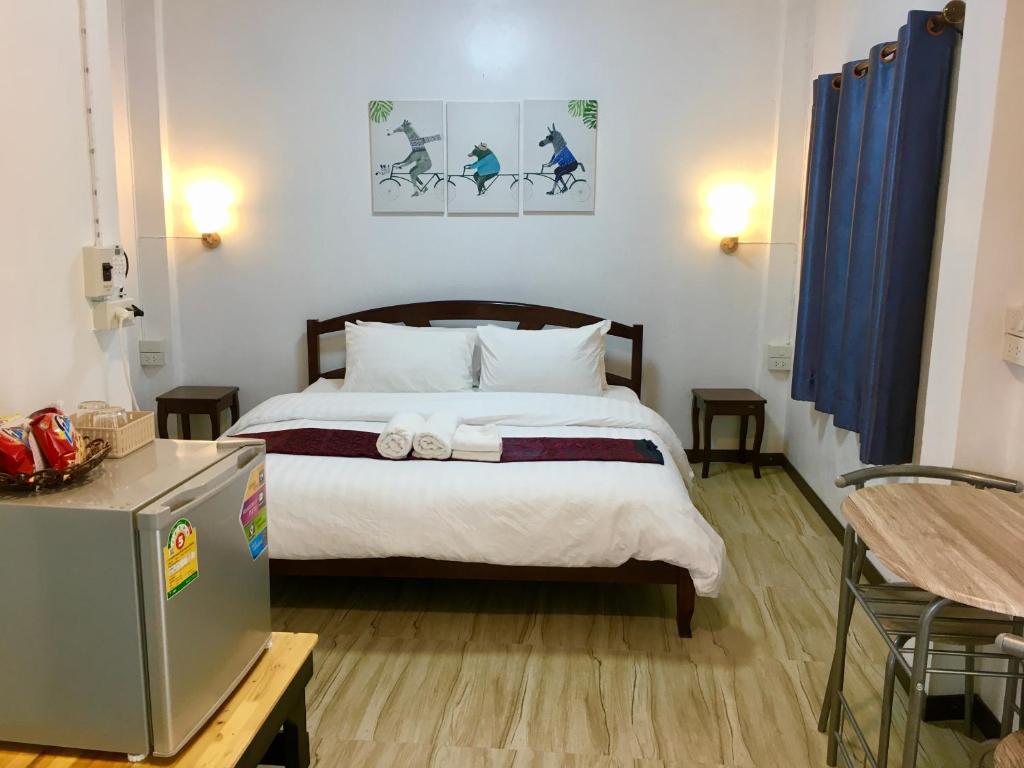 - une chambre avec un grand lit et des rideaux bleus dans l'établissement T&N home Ayutthaya, à Phra Nakhon Si Ayutthaya