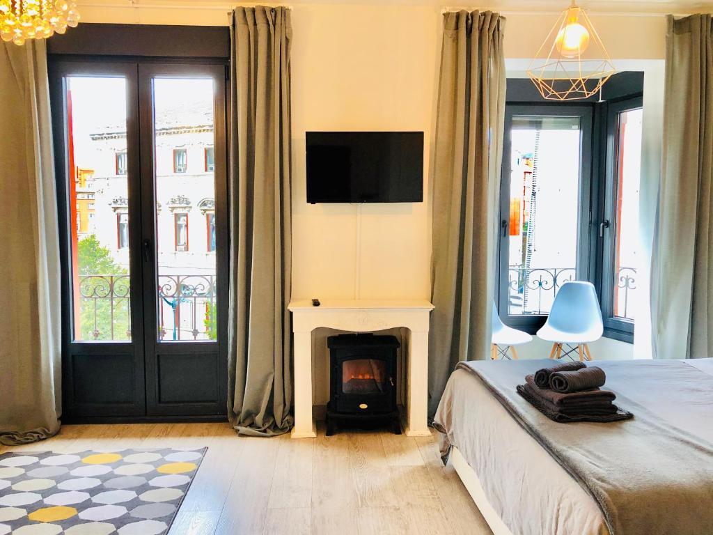 a bedroom with a bed with a fireplace and a tv at Espectacular suite con vistas a la ría in Bilbao