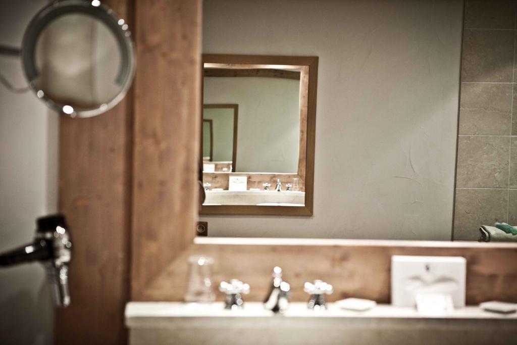 a bathroom with a sink and a mirror at Hôtel Les Barmes De l'Ours in Val-d'Isère