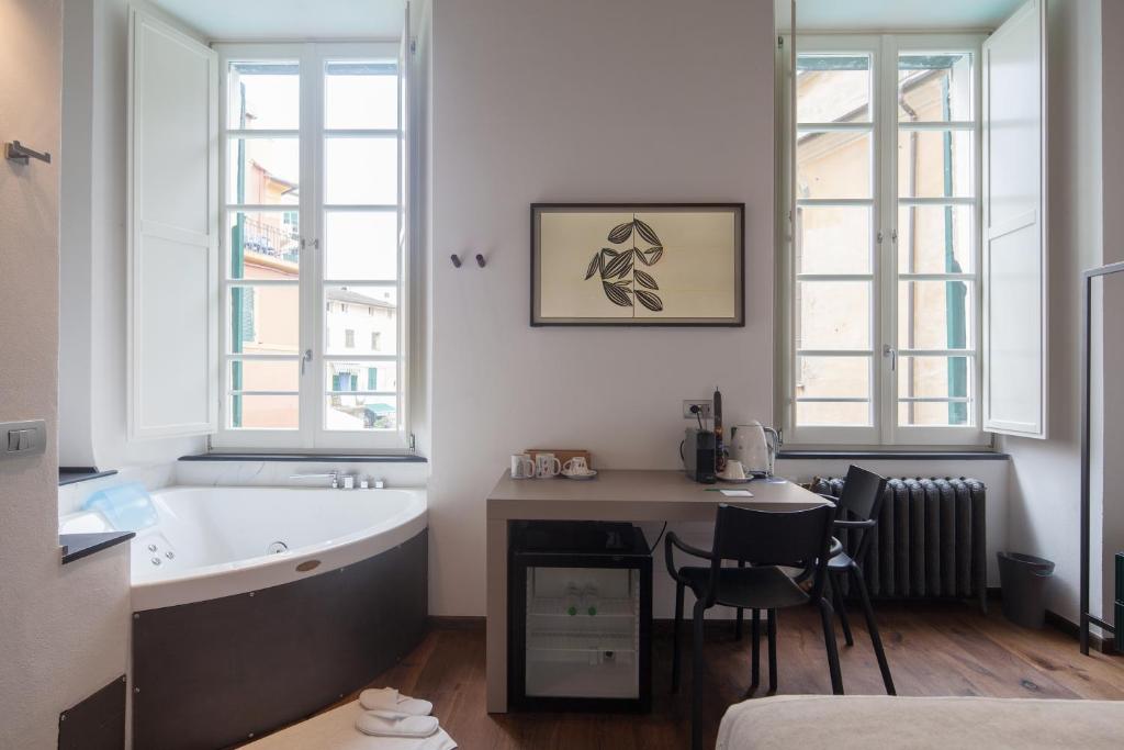 W łazience znajduje się wanna, stół i krzesła. w obiekcie Piccolo Principe Affittacamere w mieście Monterosso al Mare