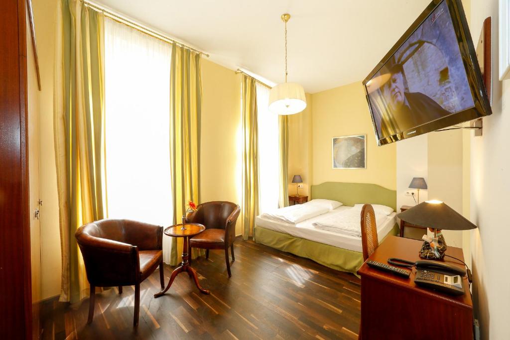 ウィーンにあるSelf Check-in Time Out City Hotel Viennaのベッド、テーブル、椅子が備わるホテルルームです。