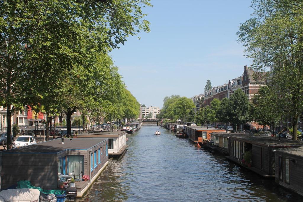a canal with houses and a boat in a city at Great Apartment Amsterdam in Amsterdam